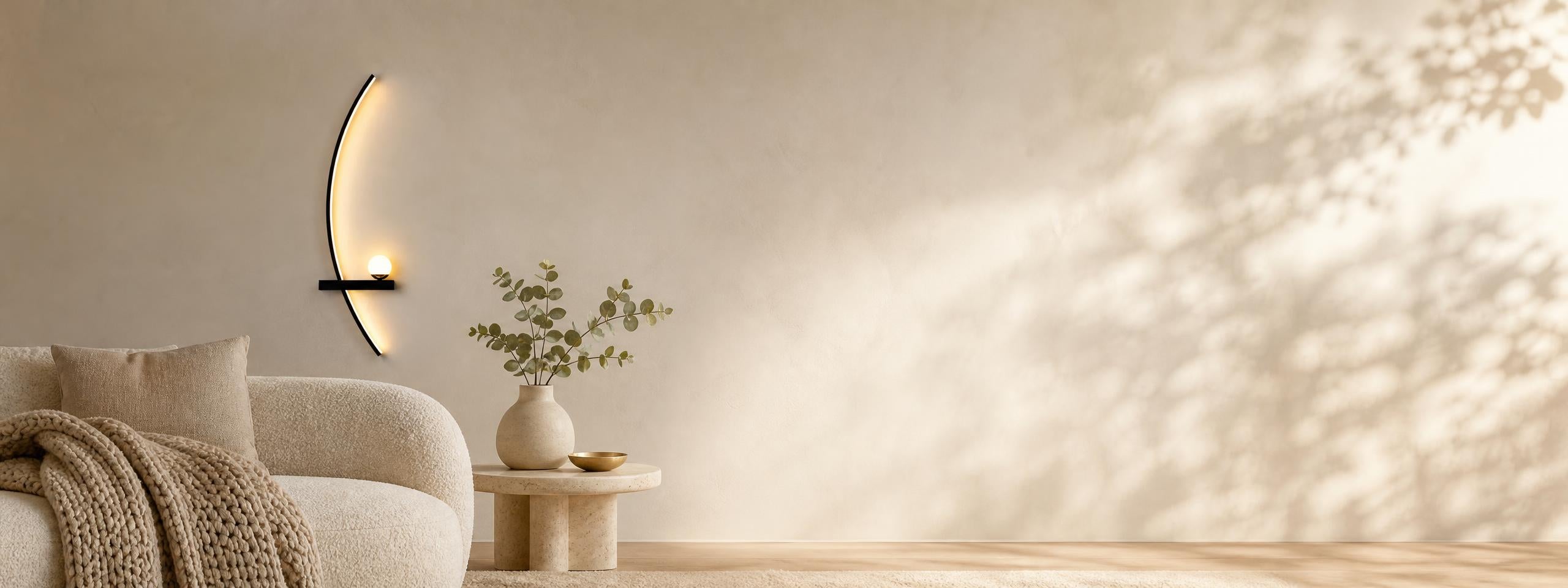 Minimal arc wall lamp glowing above an ivory sofa